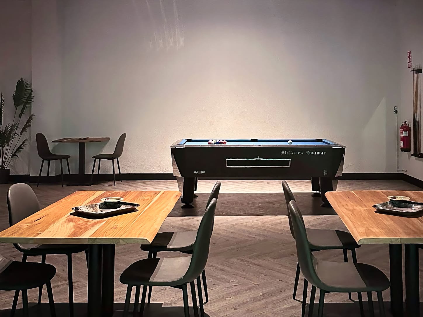 The entertainment area at Four Twenty cannabis club in Valencia, featuring a classic Billares Solimar pool table under ambient lighting, surrounded by wooden tables and seating.
