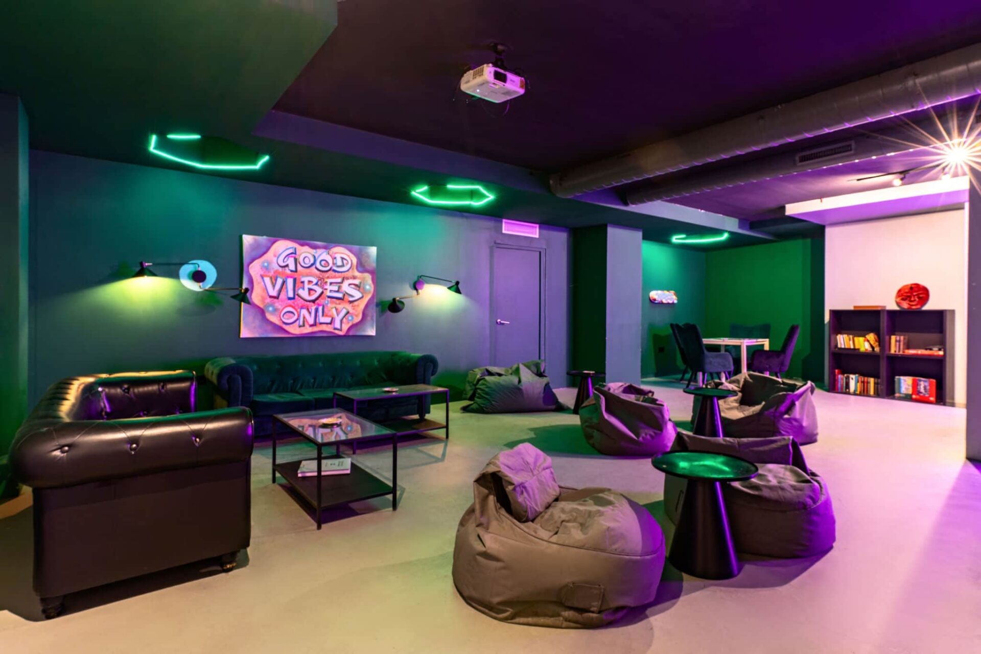 Cozy lounge area of the cannabis club Gusto Green in Barcelona with bean bags and neon lights