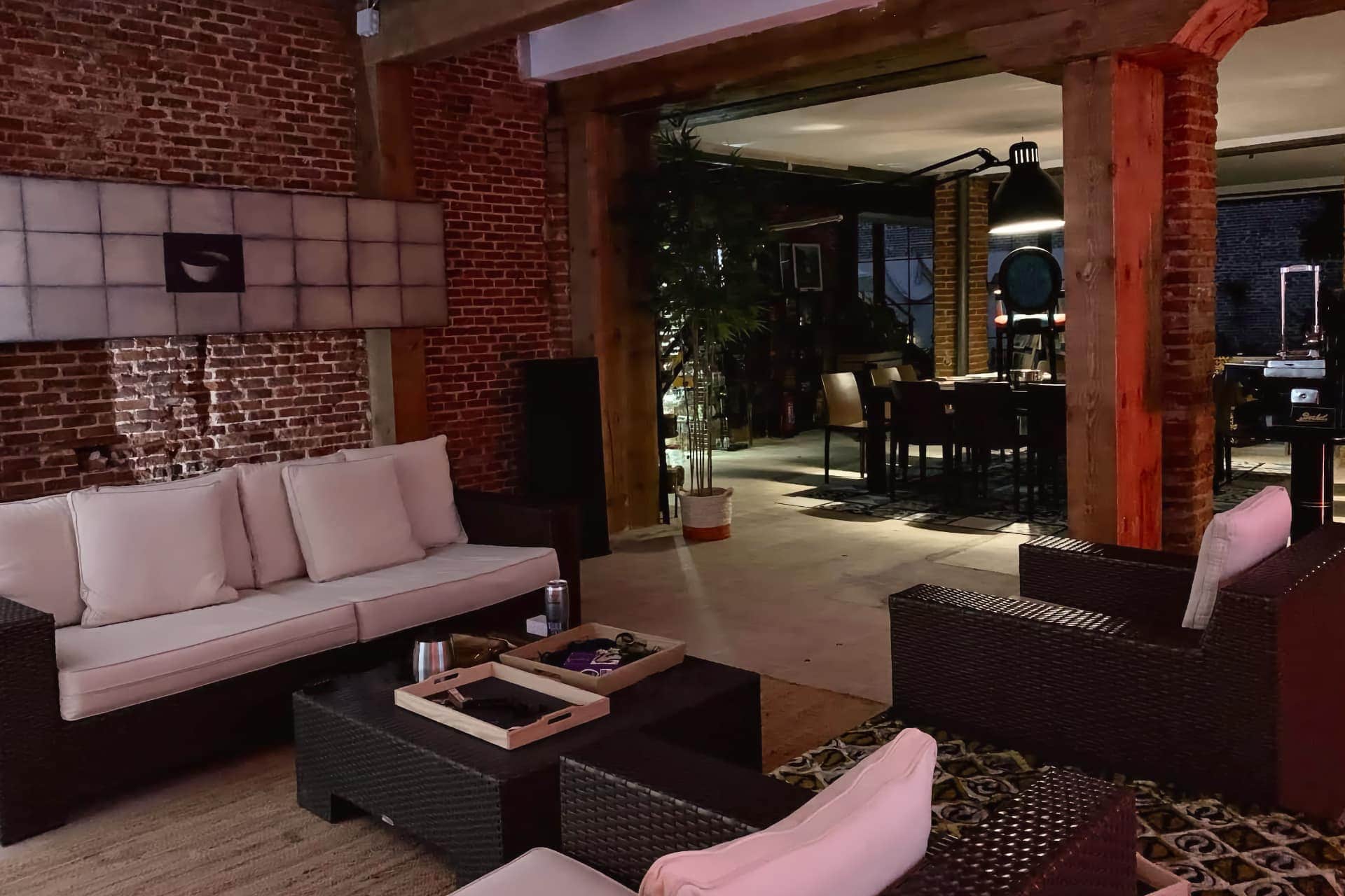 Modern lounge in the Madrid Noviciado cannabis club with brick walls and rattan sofas