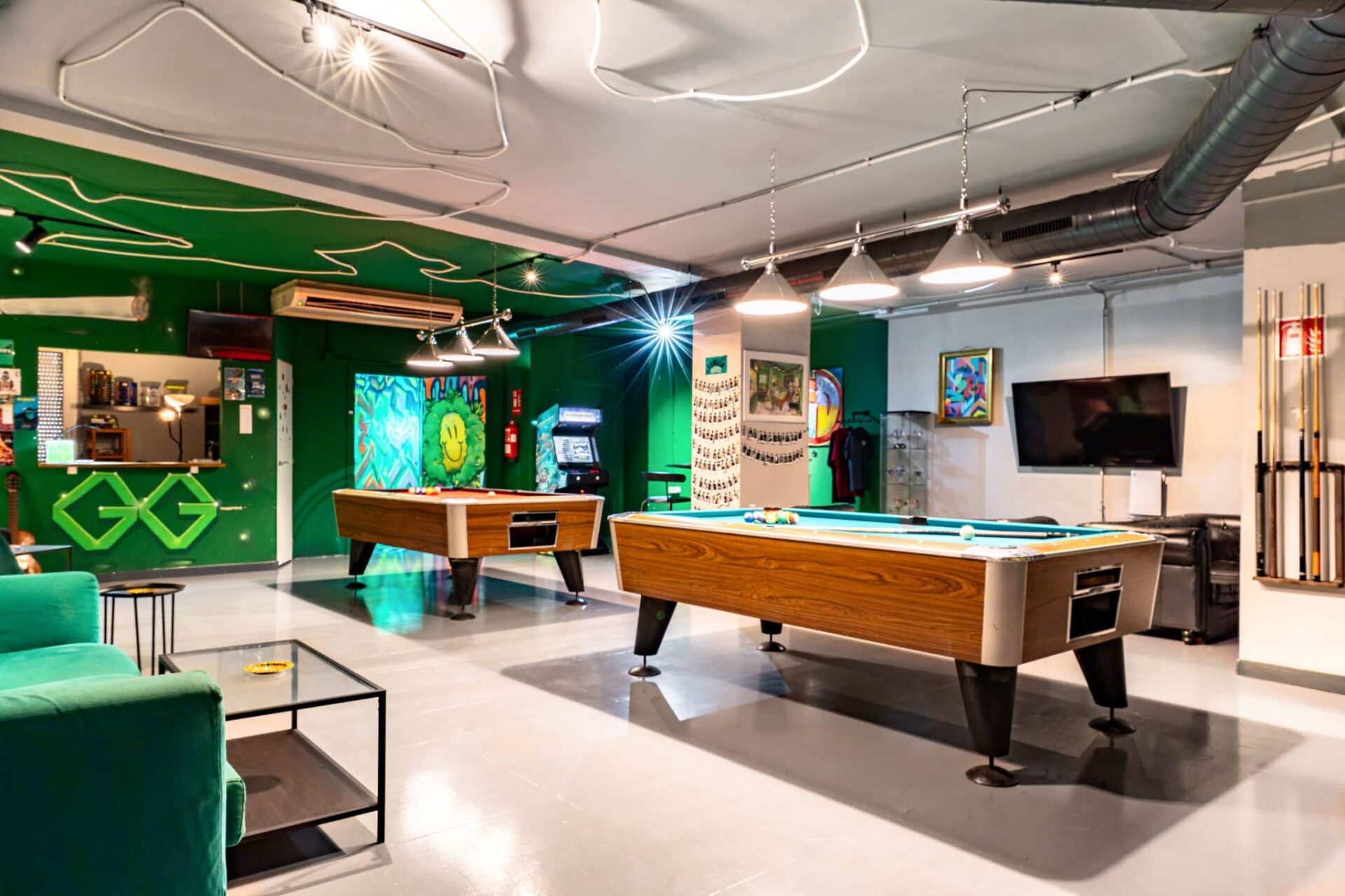 Green-themed lounge with pool tables at the social cannabis club Gusto Green Barcelona