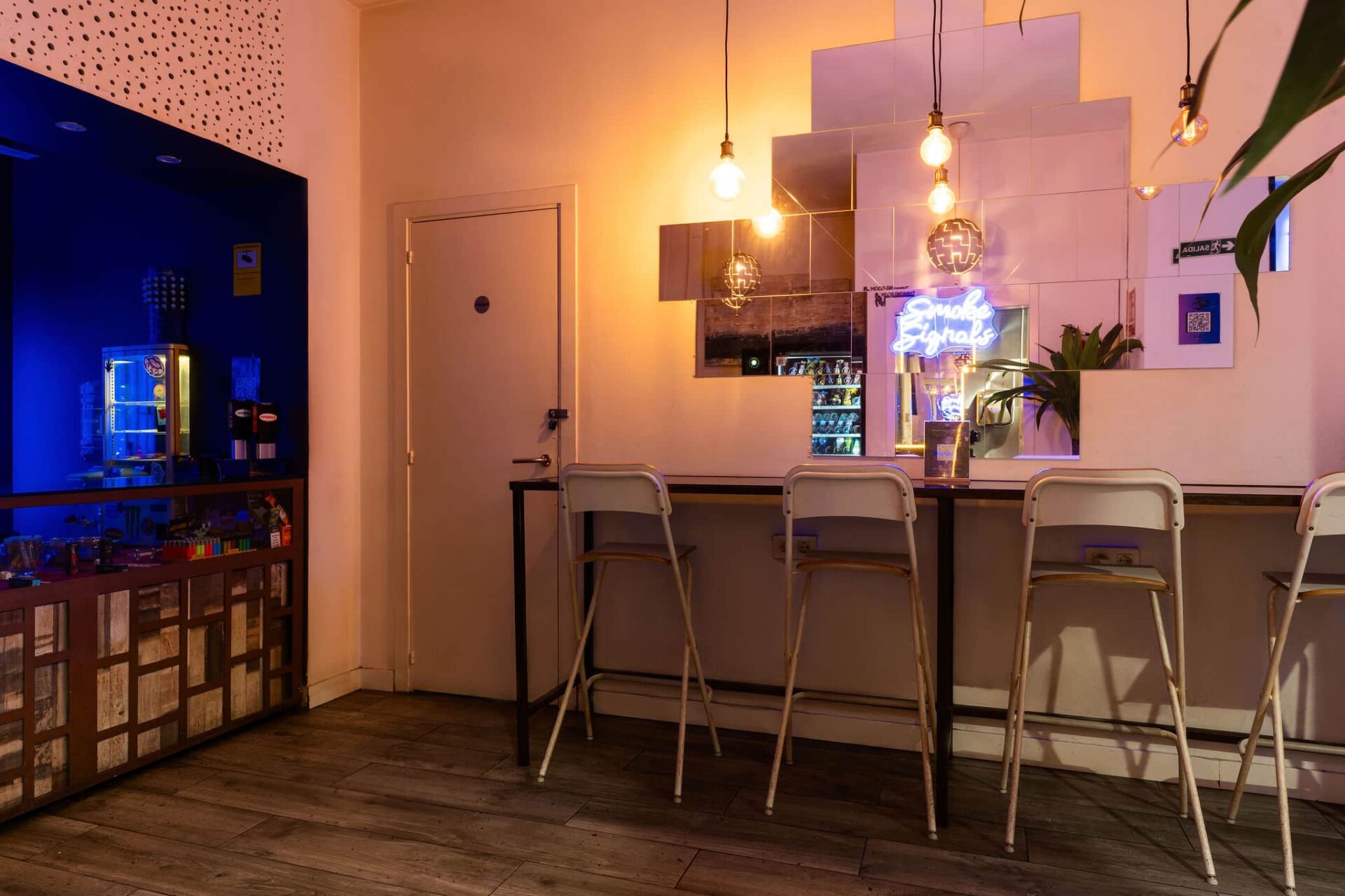 Bar counter with mirrors and neon sign in the Barcelona Smoke Signals cannabis club